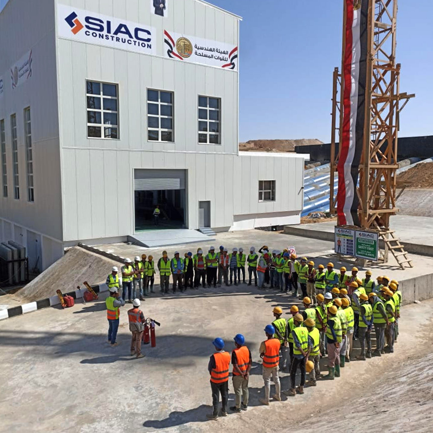 a group of construction workers in safety vests standing in a circle