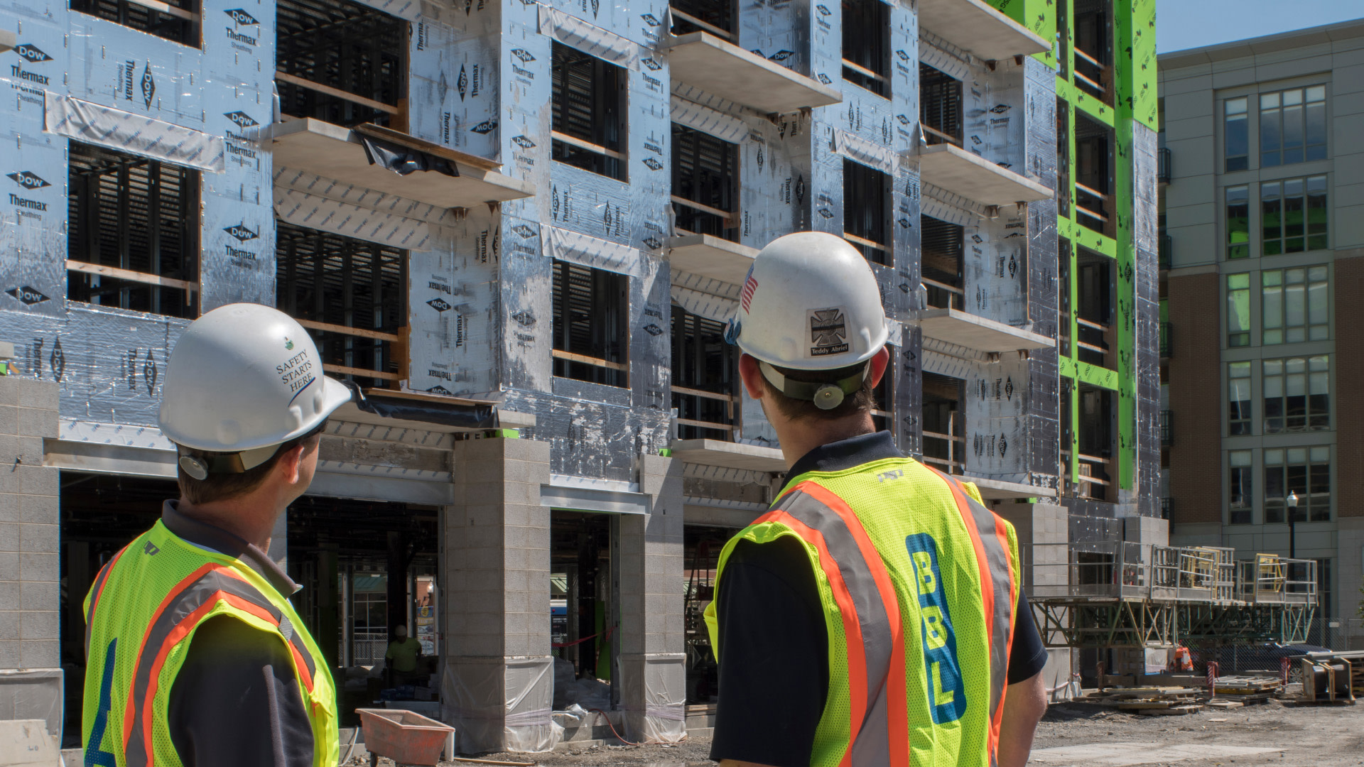 BBL construction workers looking at a building under construction