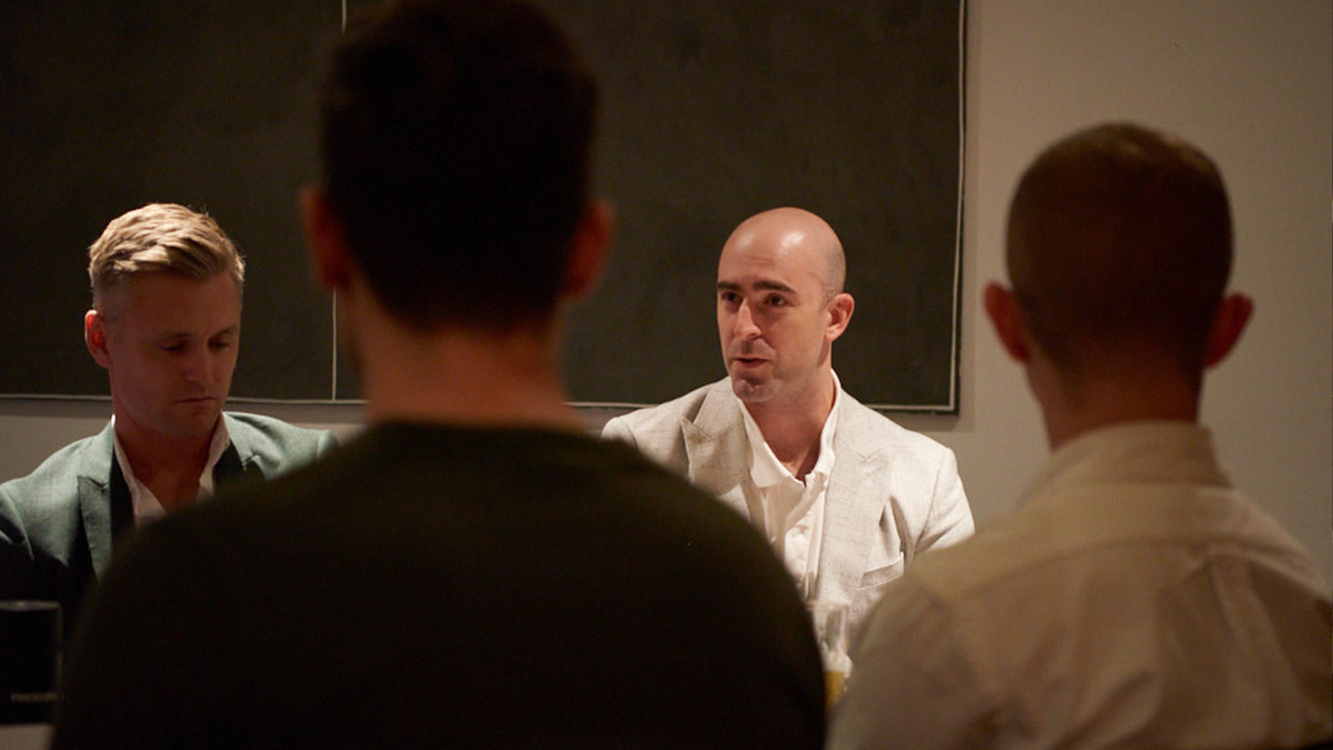 A group of people sitting at a table having a conversation