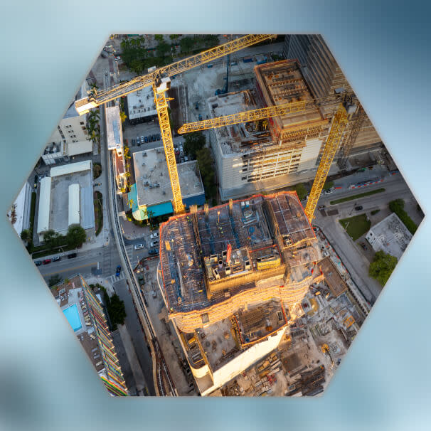 Aerial view of a downtown construction site with yellow tower cranes