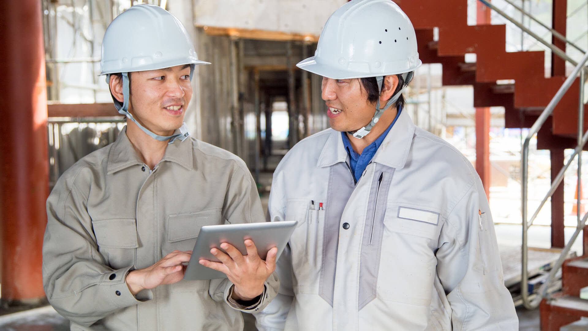 Contractors having a conversation while working on a tablet