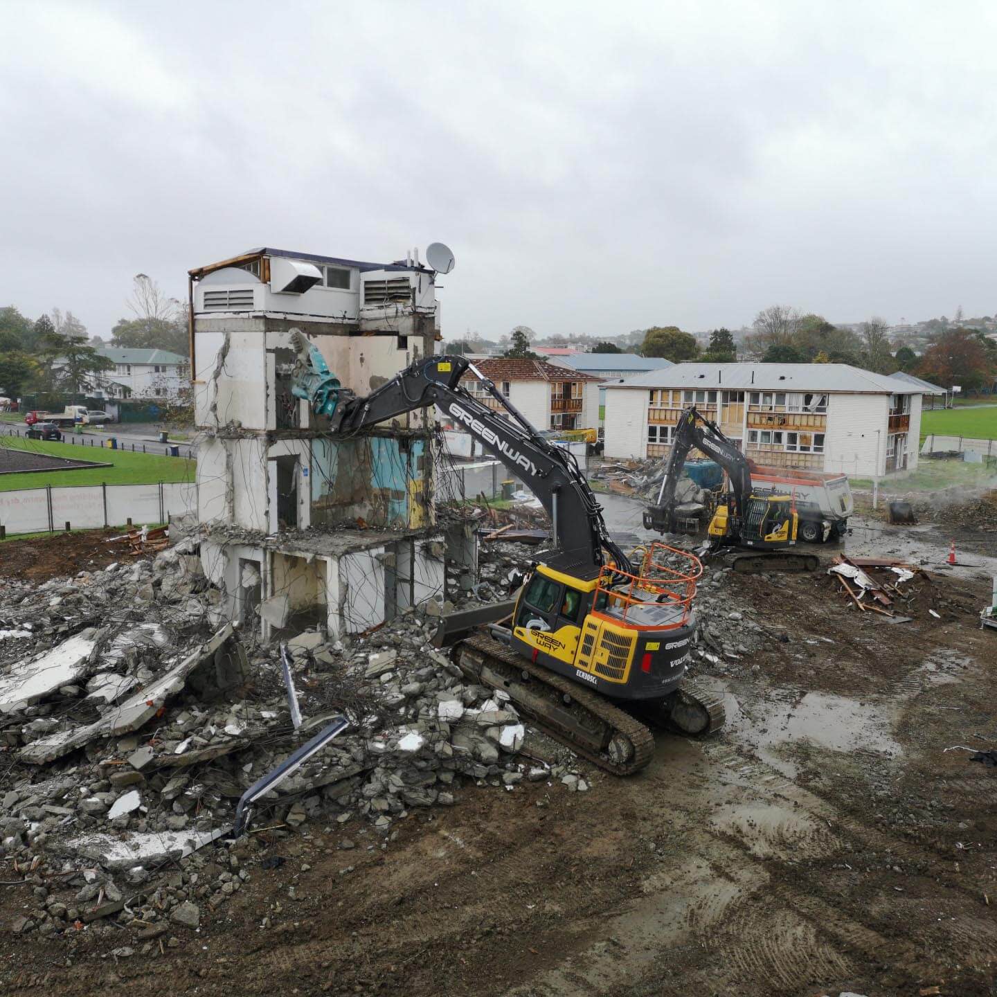 Heavy machinery taring down an old two-story building