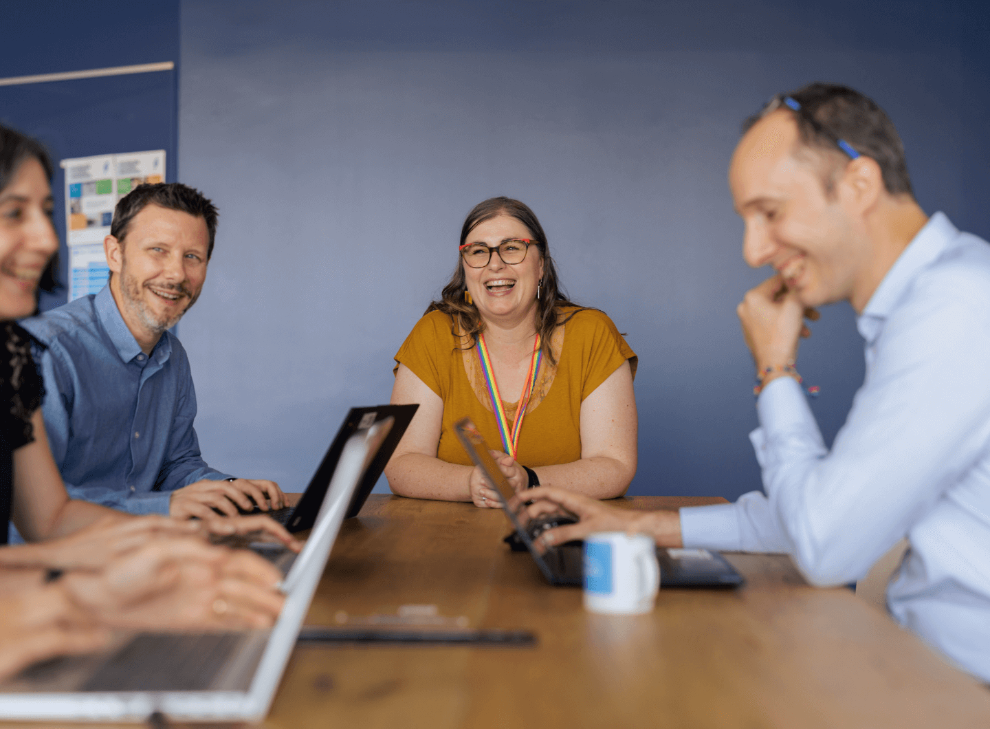 Workers sitting around a desk discussing work