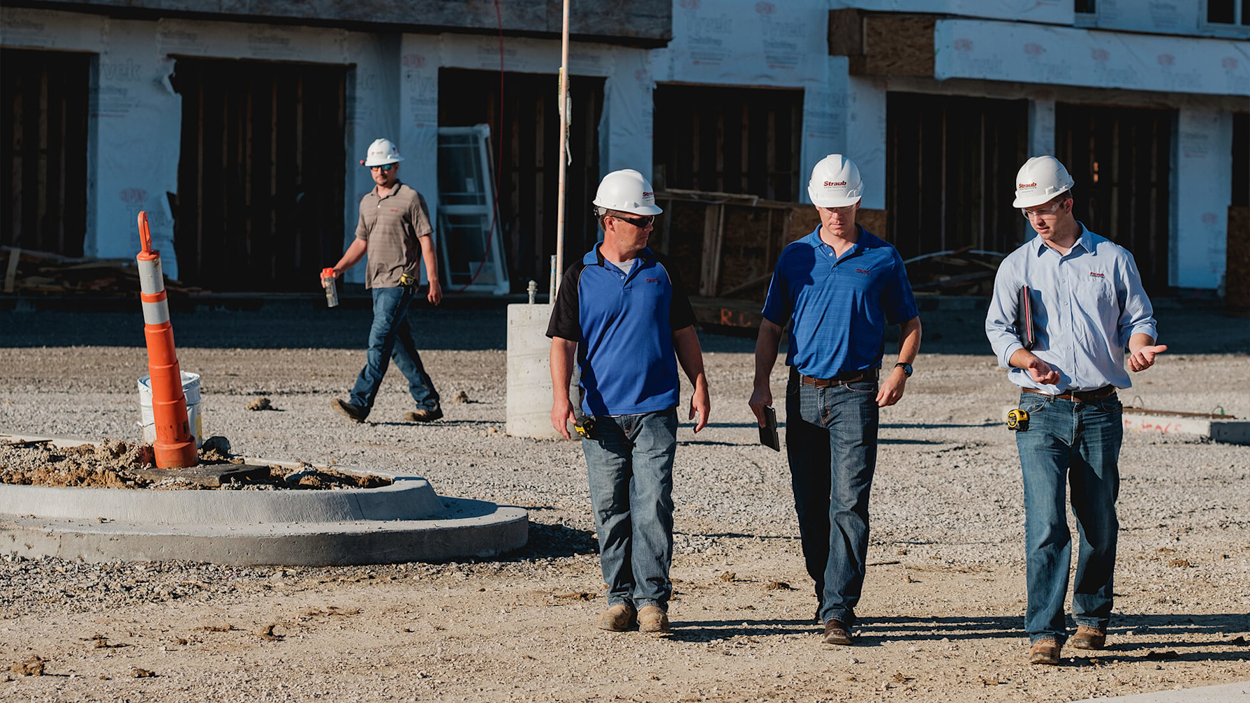 A group of men wearing hard hats walking outside
