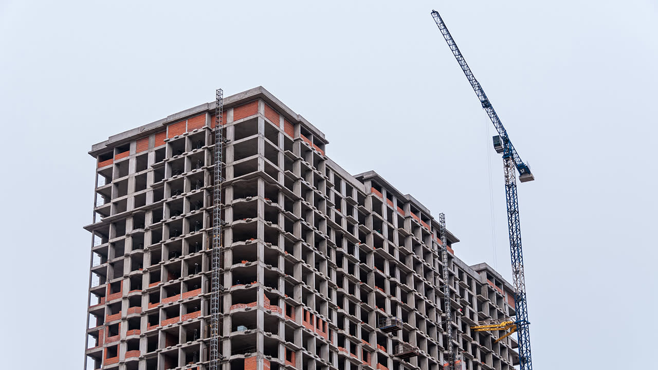 Building under construction with a transporter carying pieces