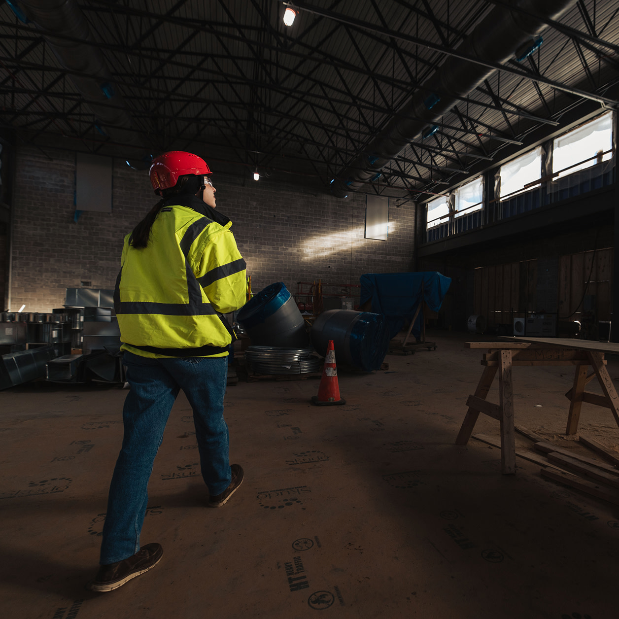 A woman contractor walking on an empty building