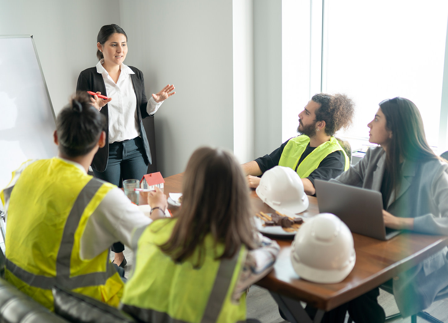 A woman giving a presentation to a group of people in a meeting room