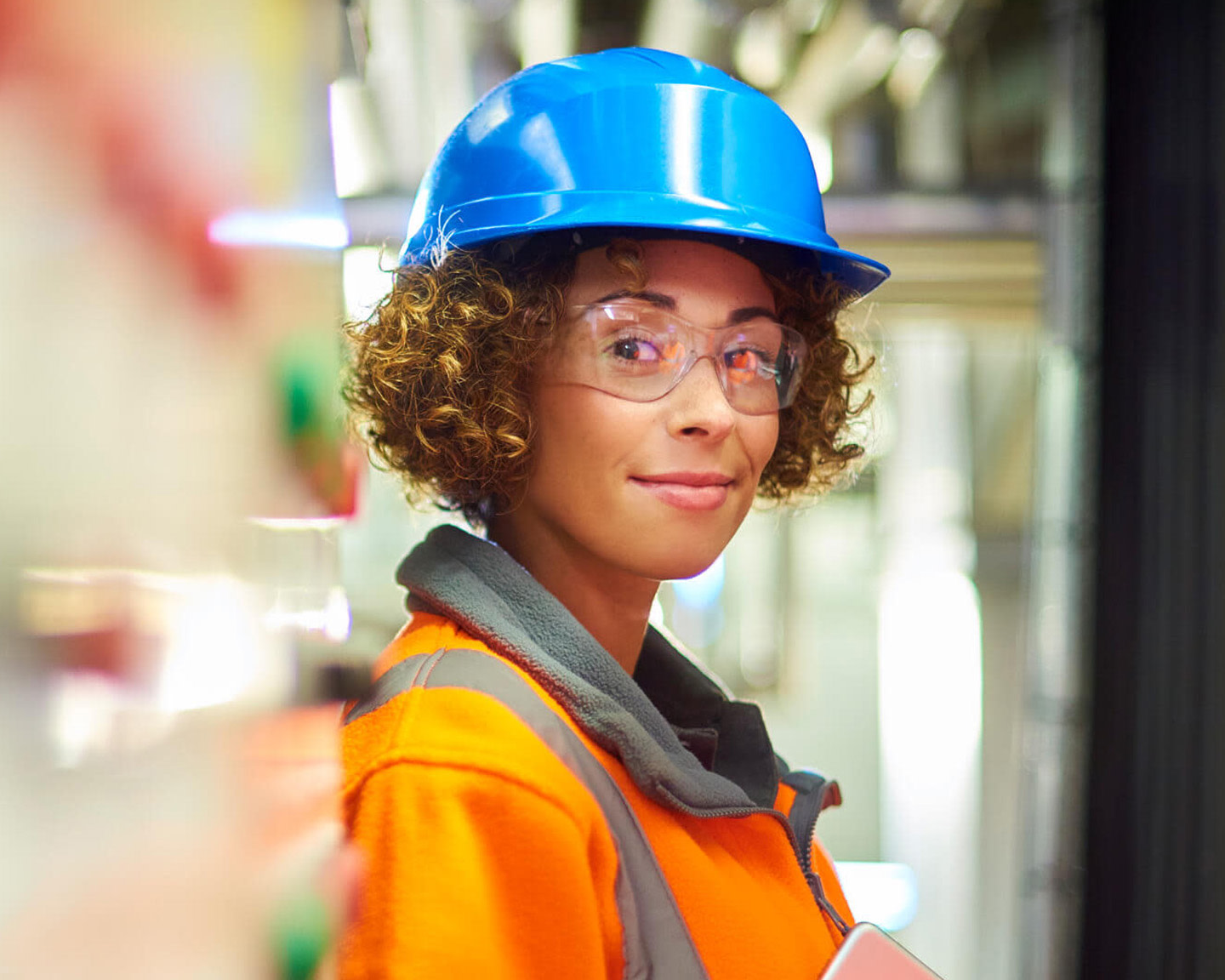 Subcontractor smiling to the camera wearing her safety glasses