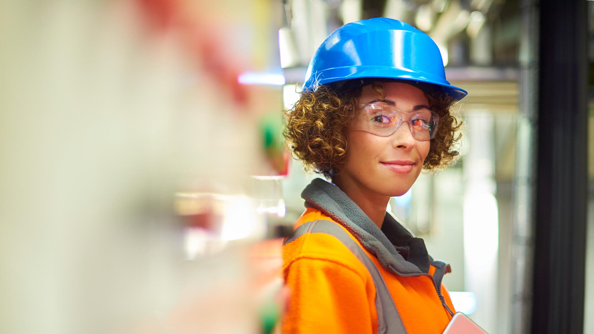 Subcontractor smiling to the camera wearing safety glasses