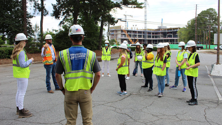 A group of people in safety vests and helmets