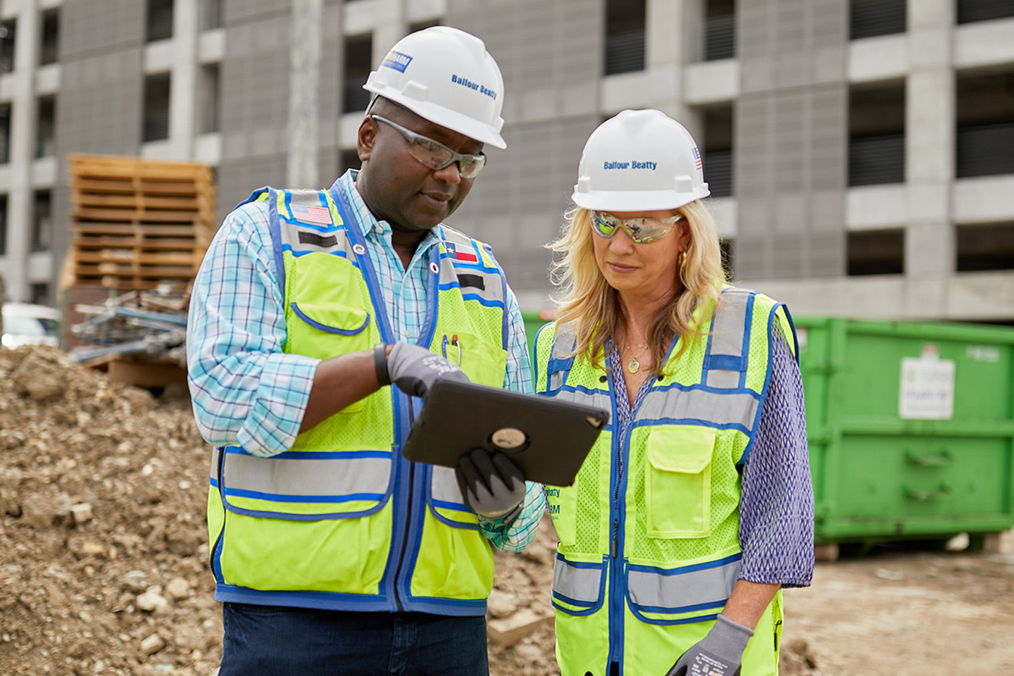 Two contractors using a tablet on the jobstie