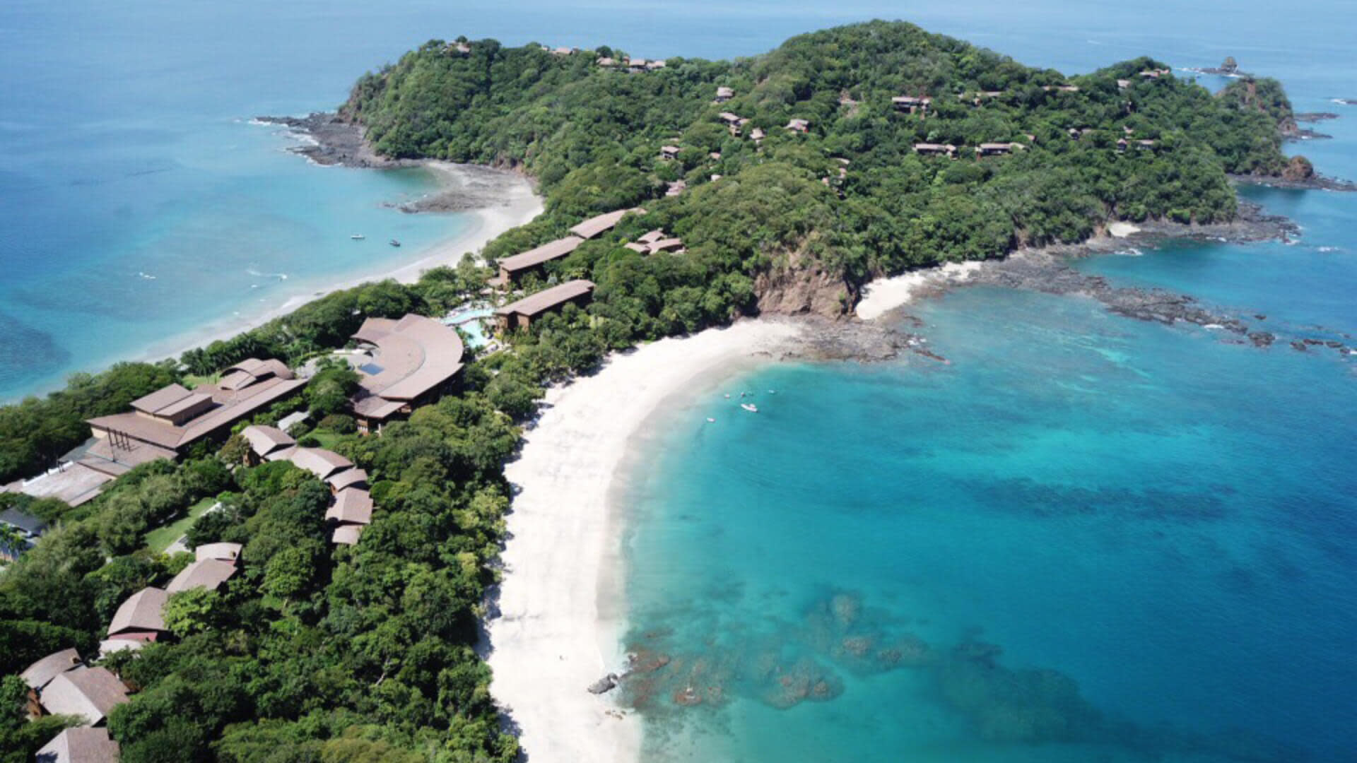 Foto de una peninsula con arboles y playa con arena blanca y agua clara