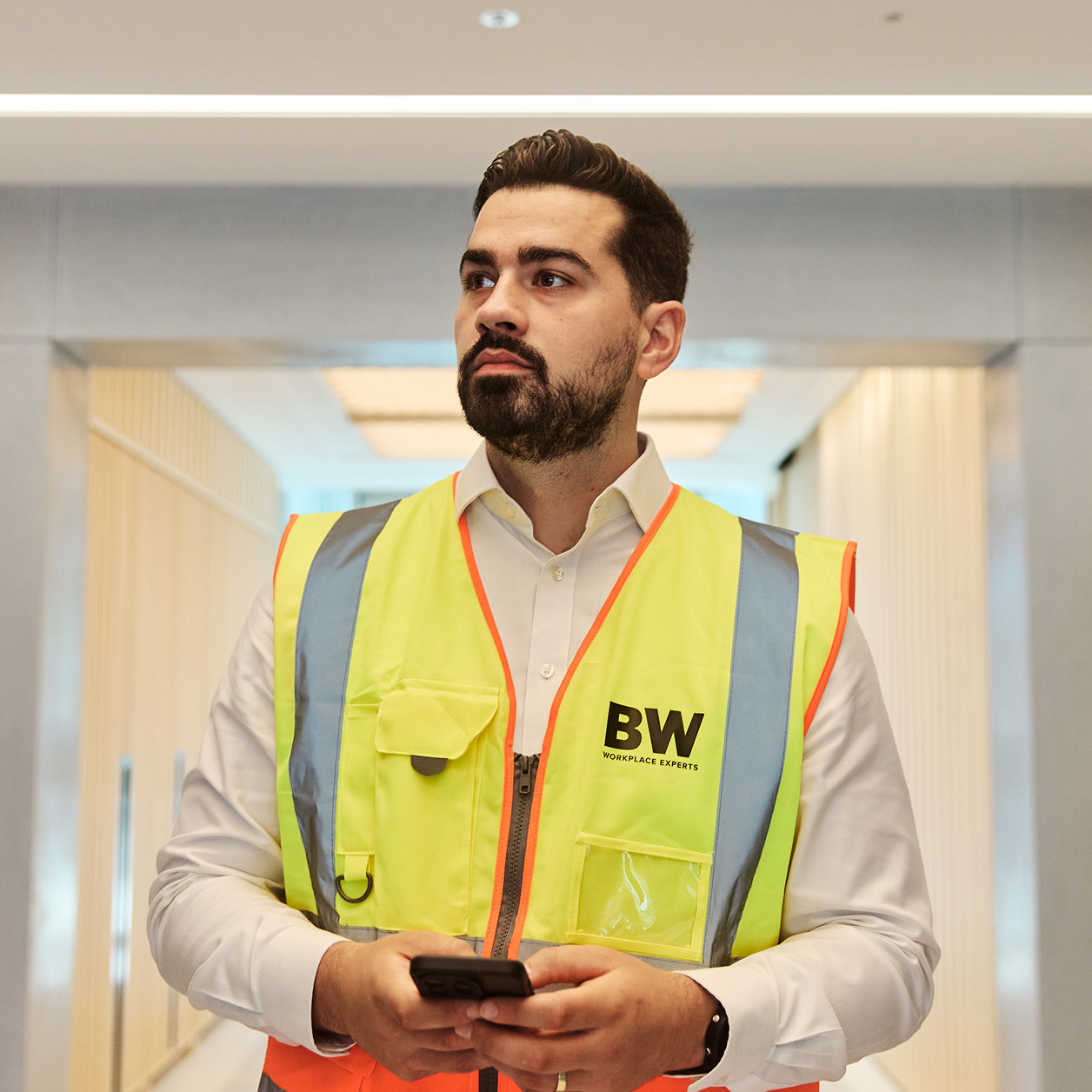 A construction worker holding a tablet at a construction site