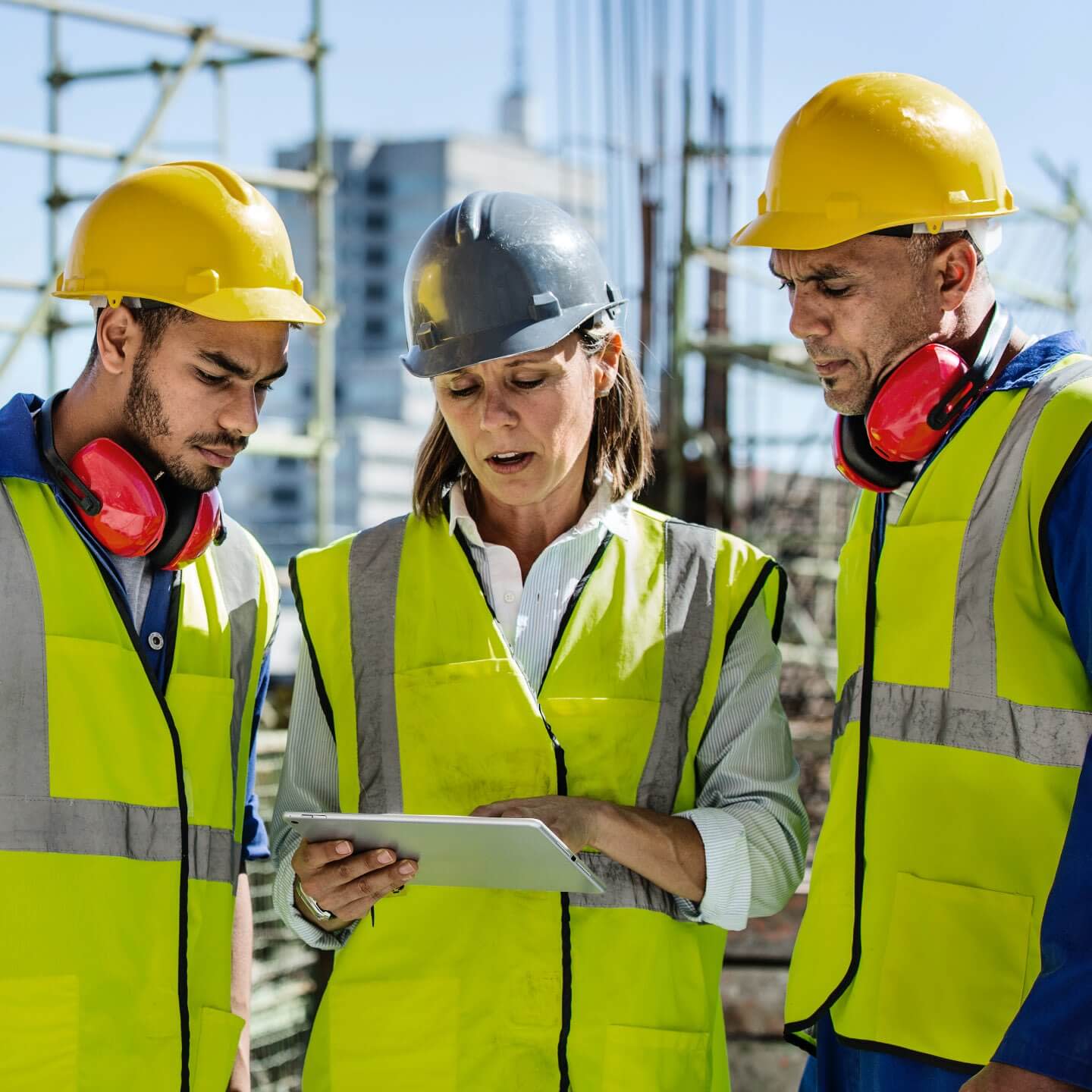 Several construction workers gathered around a tablet