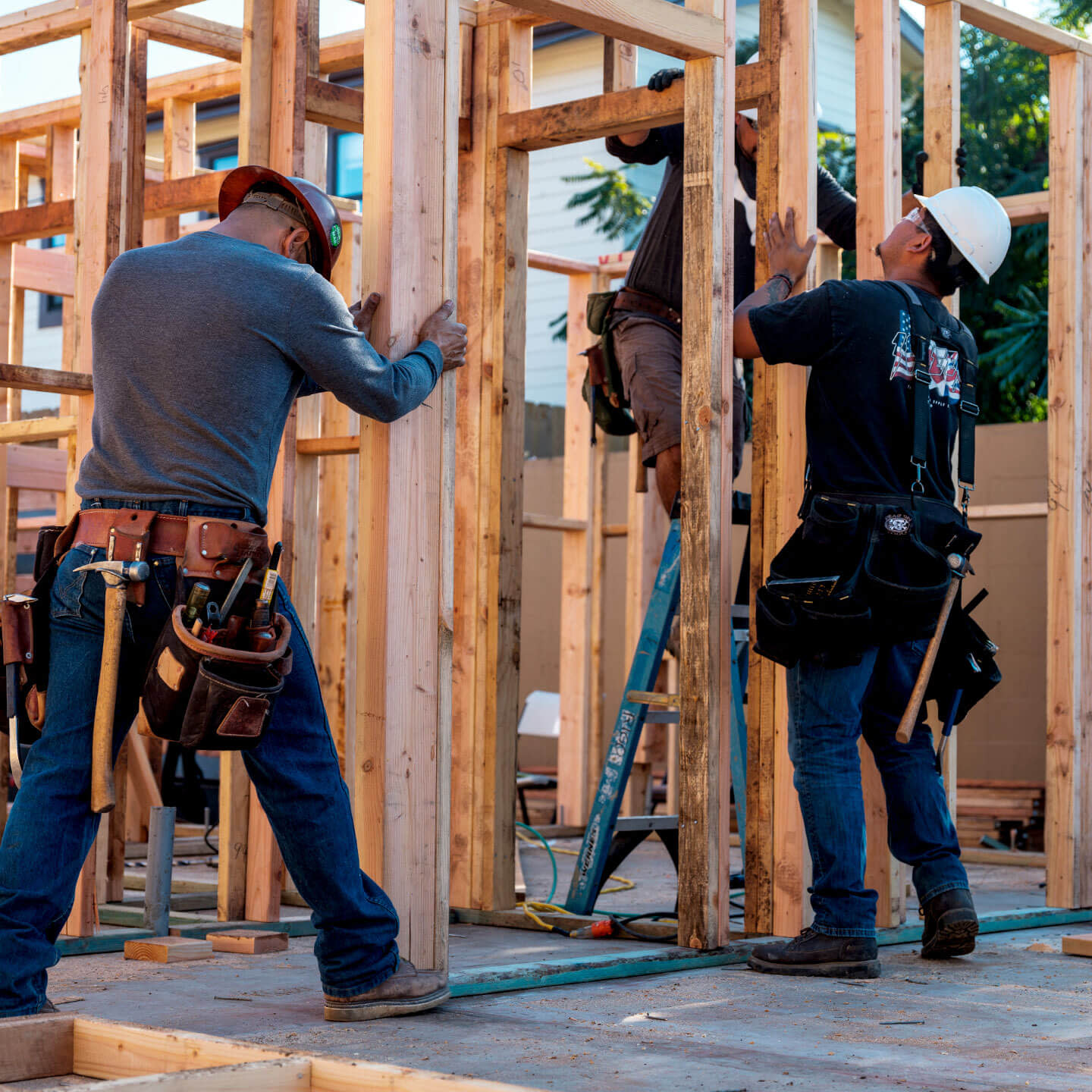 Construction workers setting up wood columns