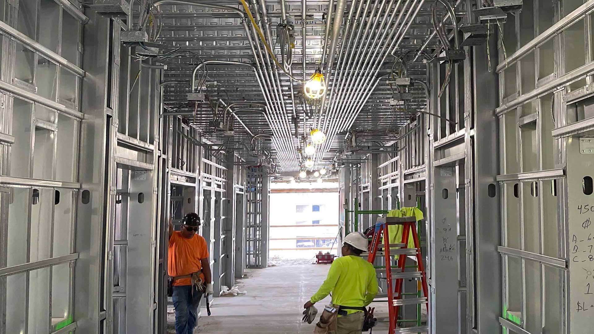 Construction workers setting up cord covers