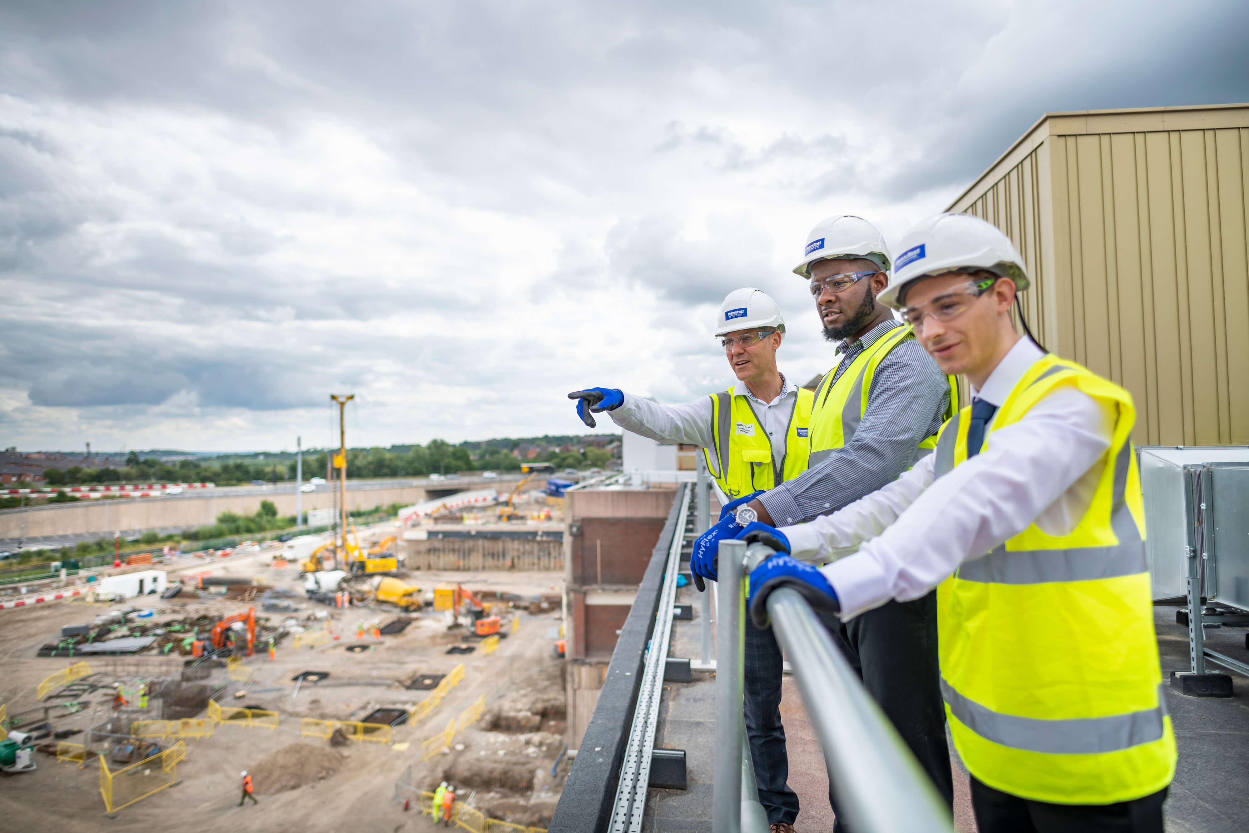 Three construction workers looking over a construction site