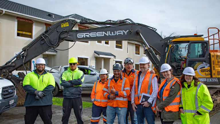 Green Way Limited workers posing in front of an excavator