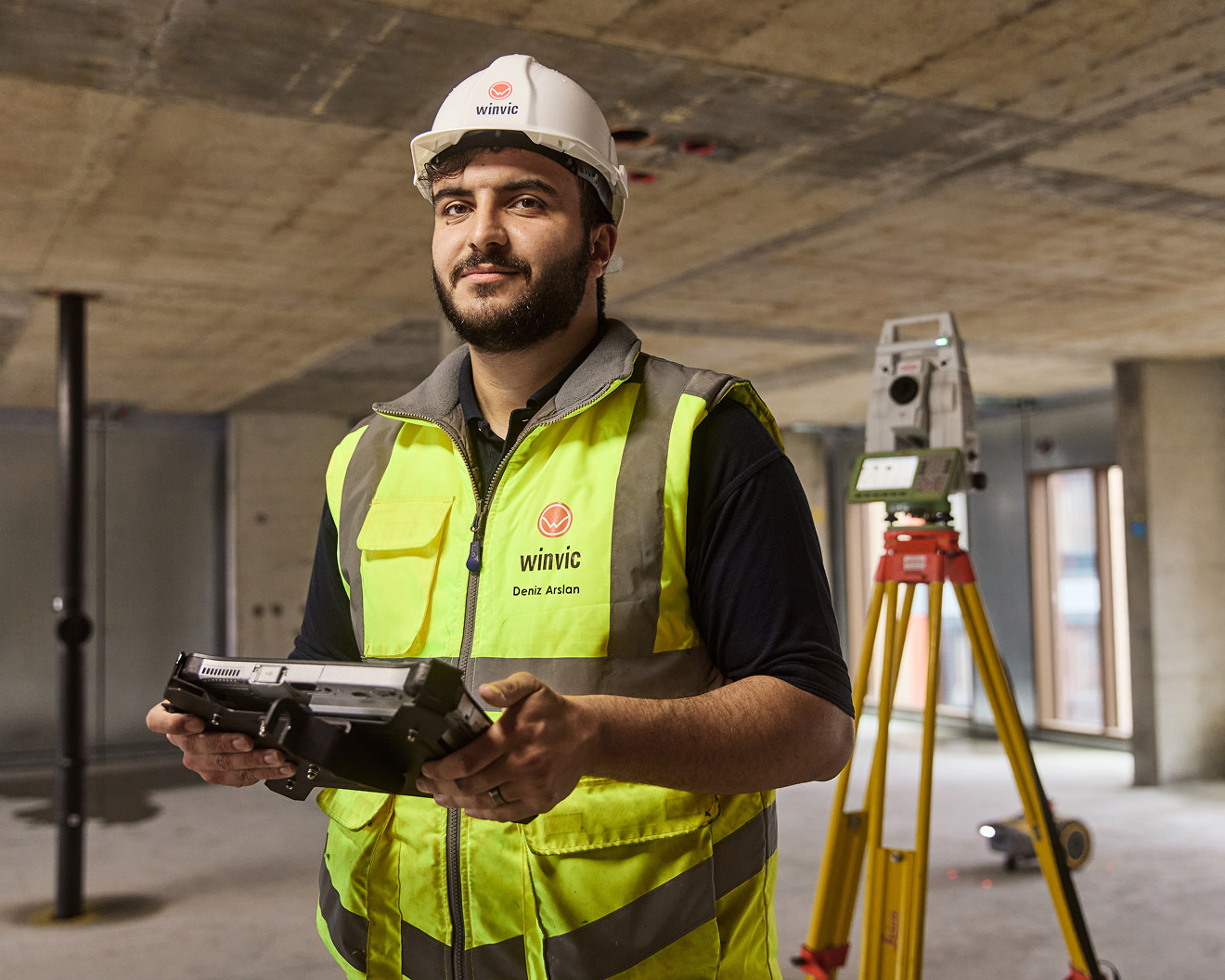 Construction worker colleagues looking at Procore software together on a device