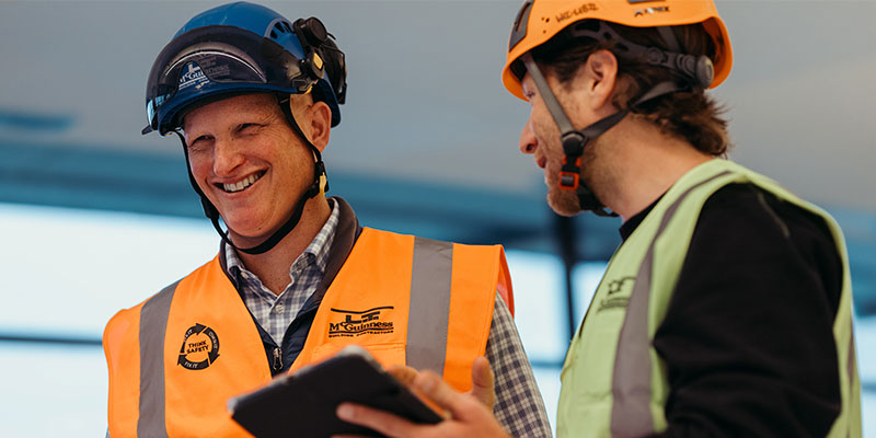 Imagine of two construction workers discussing work over an ipad