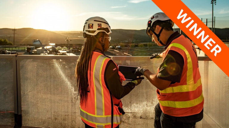 Contractors having a conversation while reviewing a project's info on a tablet