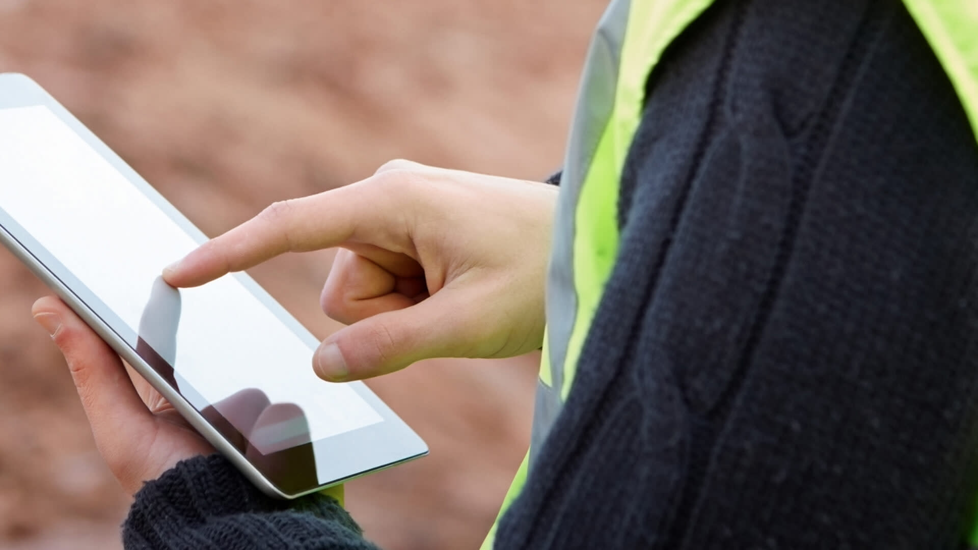 Contractor using Procore on a tablet