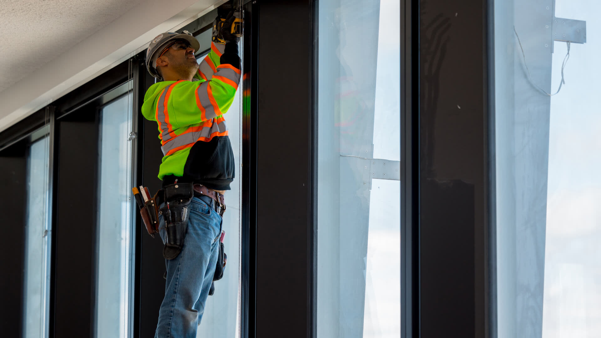 Specialty contractor drilling the top of a window