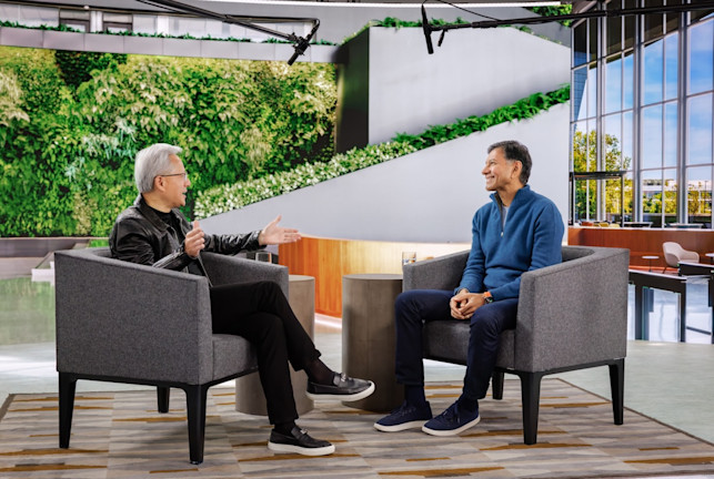 Two men having a conversation in modern office with green living wall and large windows