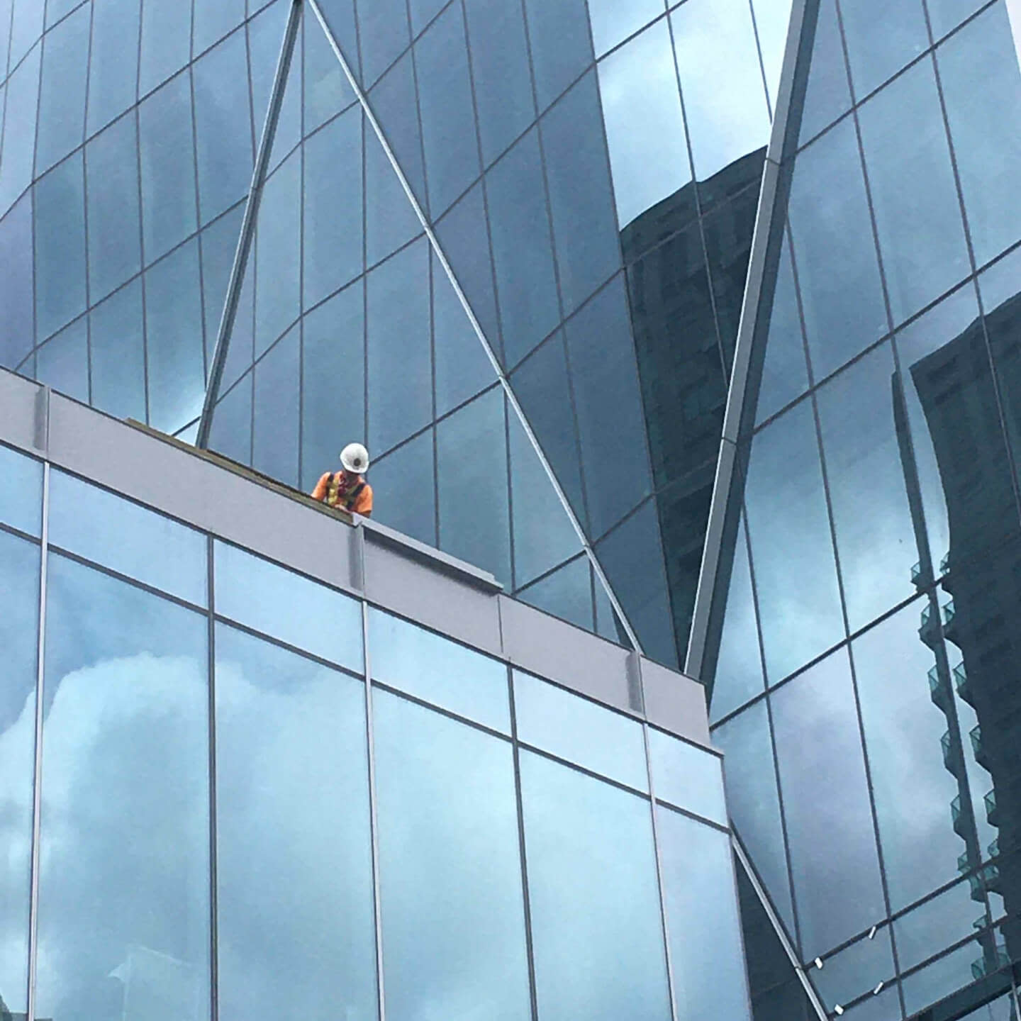 Contractor looking down from a skyscraper's rooftop