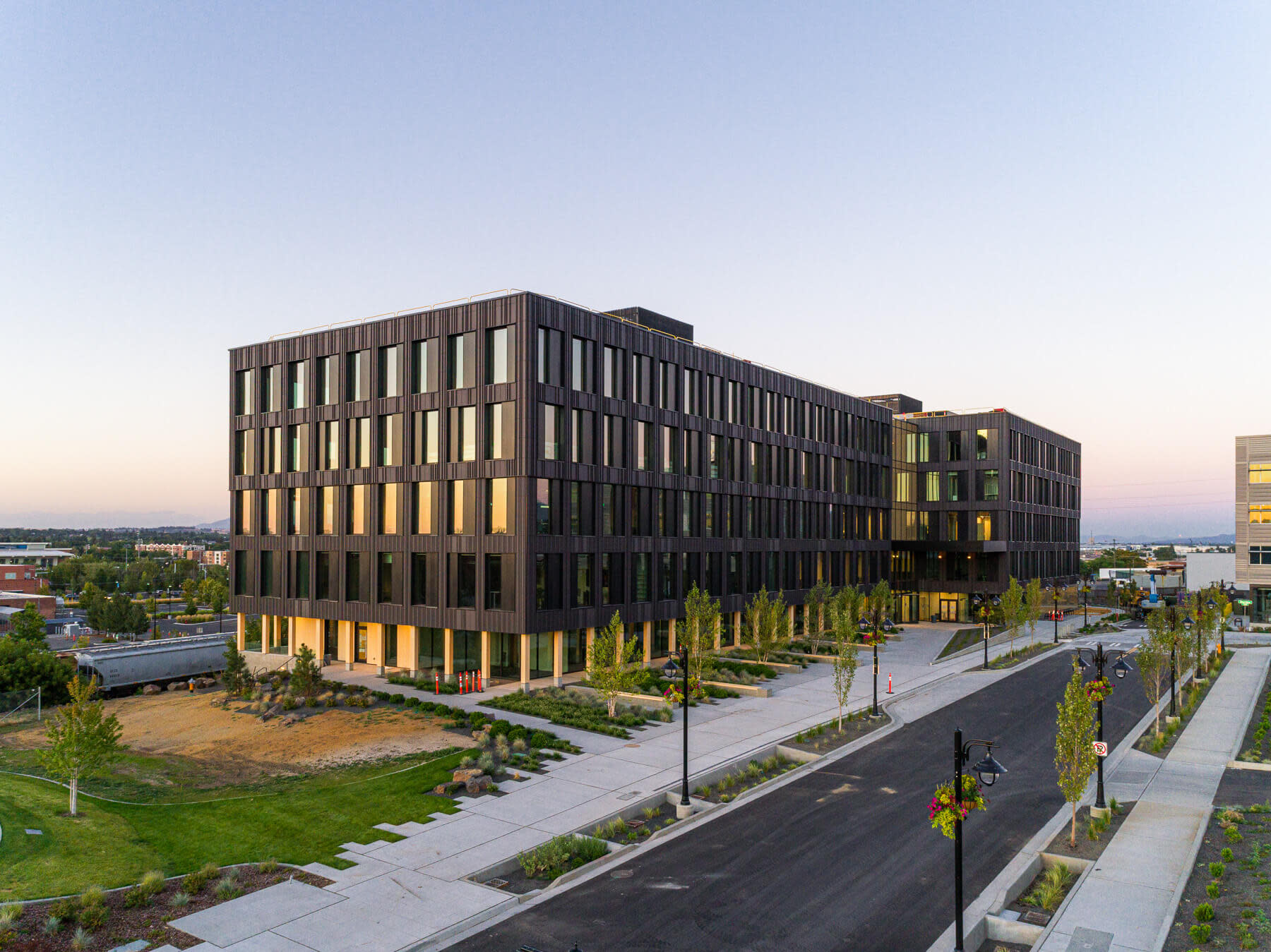 A modern office building with numerous windows, reflecting the sunlight on a clear day.