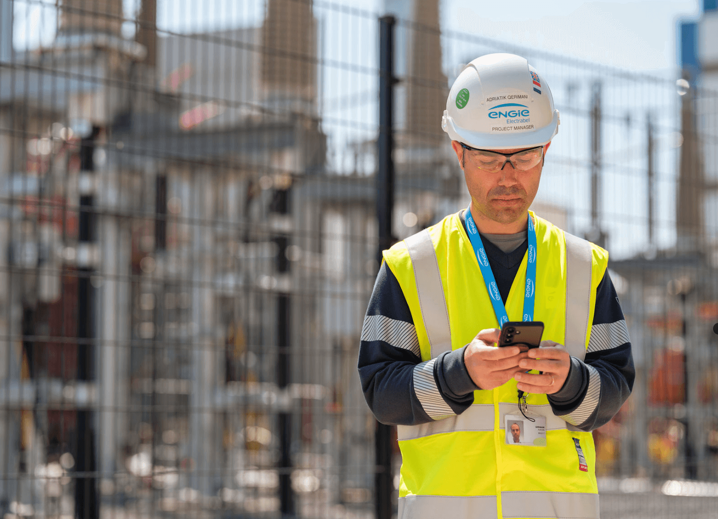 A construction worker using a phone at a battery park