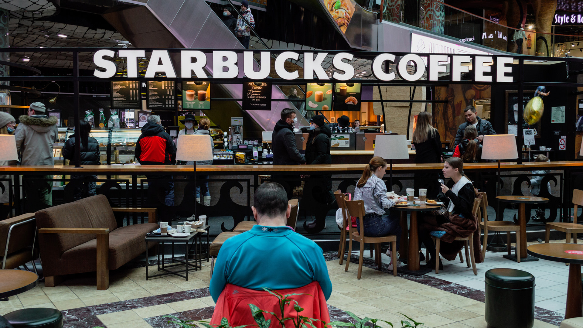 People sitting enjoying food and beverages at a Starbucks Coffee