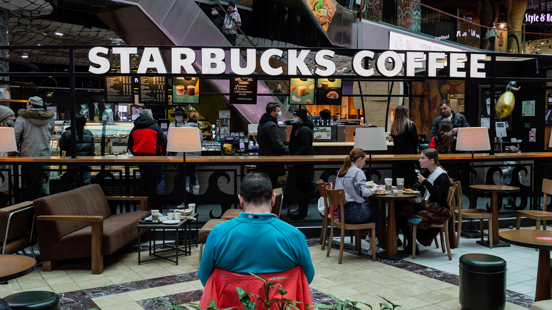 People sitting enjoying food and beverages at a Starbucks Coffee