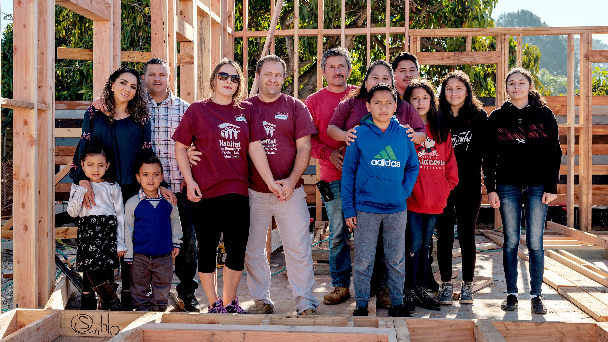 People standing in front of a home under construction