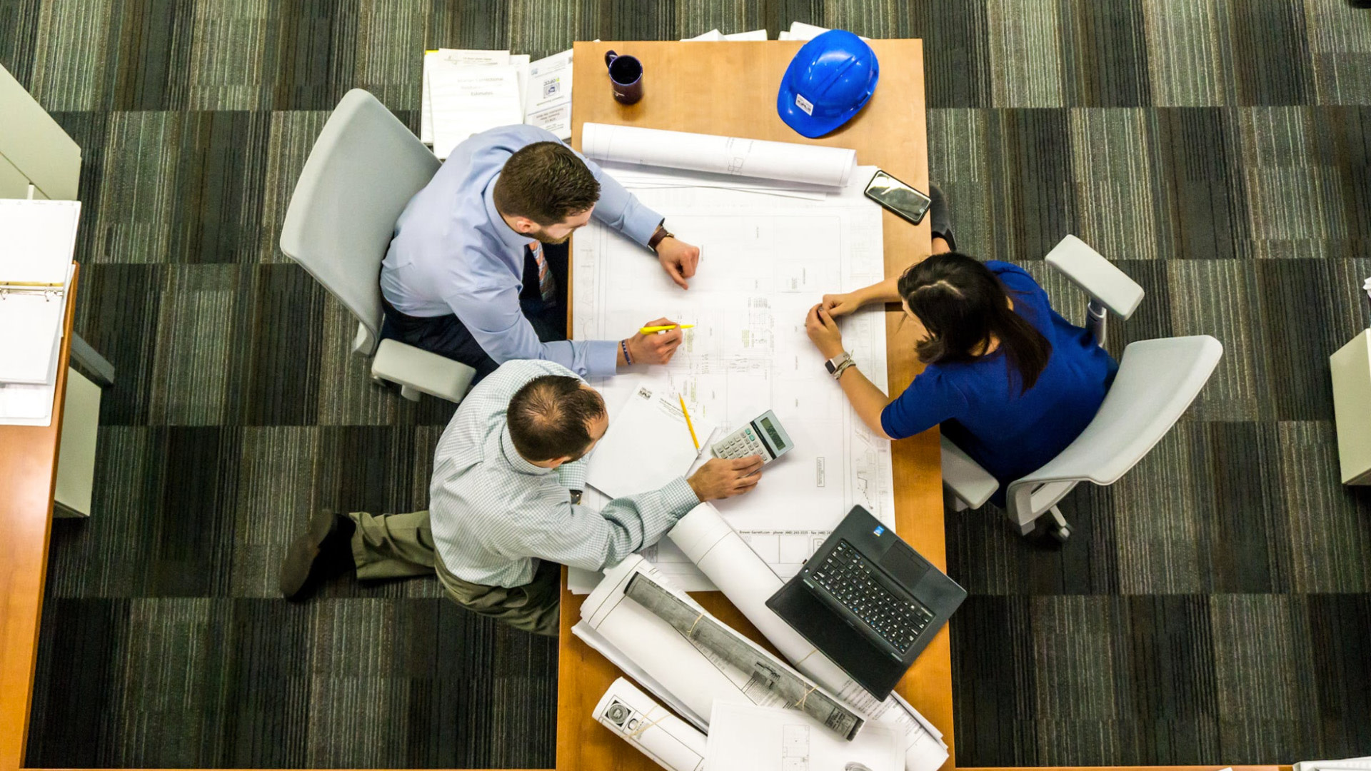 People around a table reviewing a blueprint