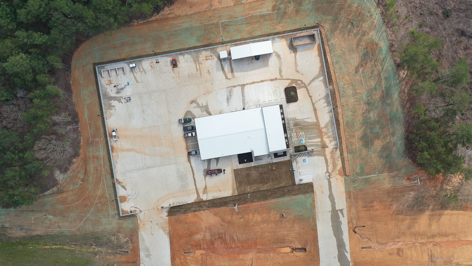 Aerial view of a warehouse with cars parked outside