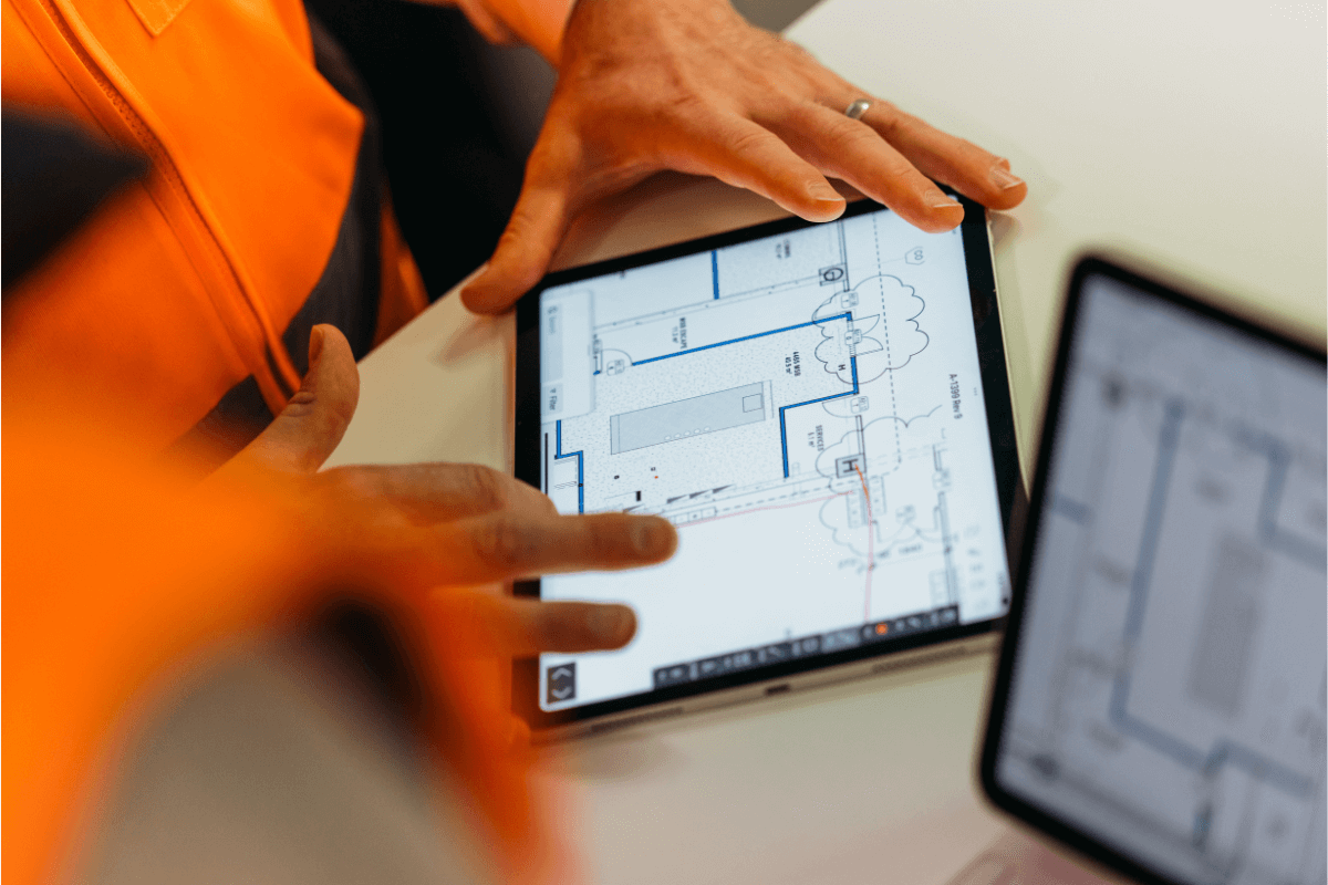 Construction workers looking at a blue print on a tablet