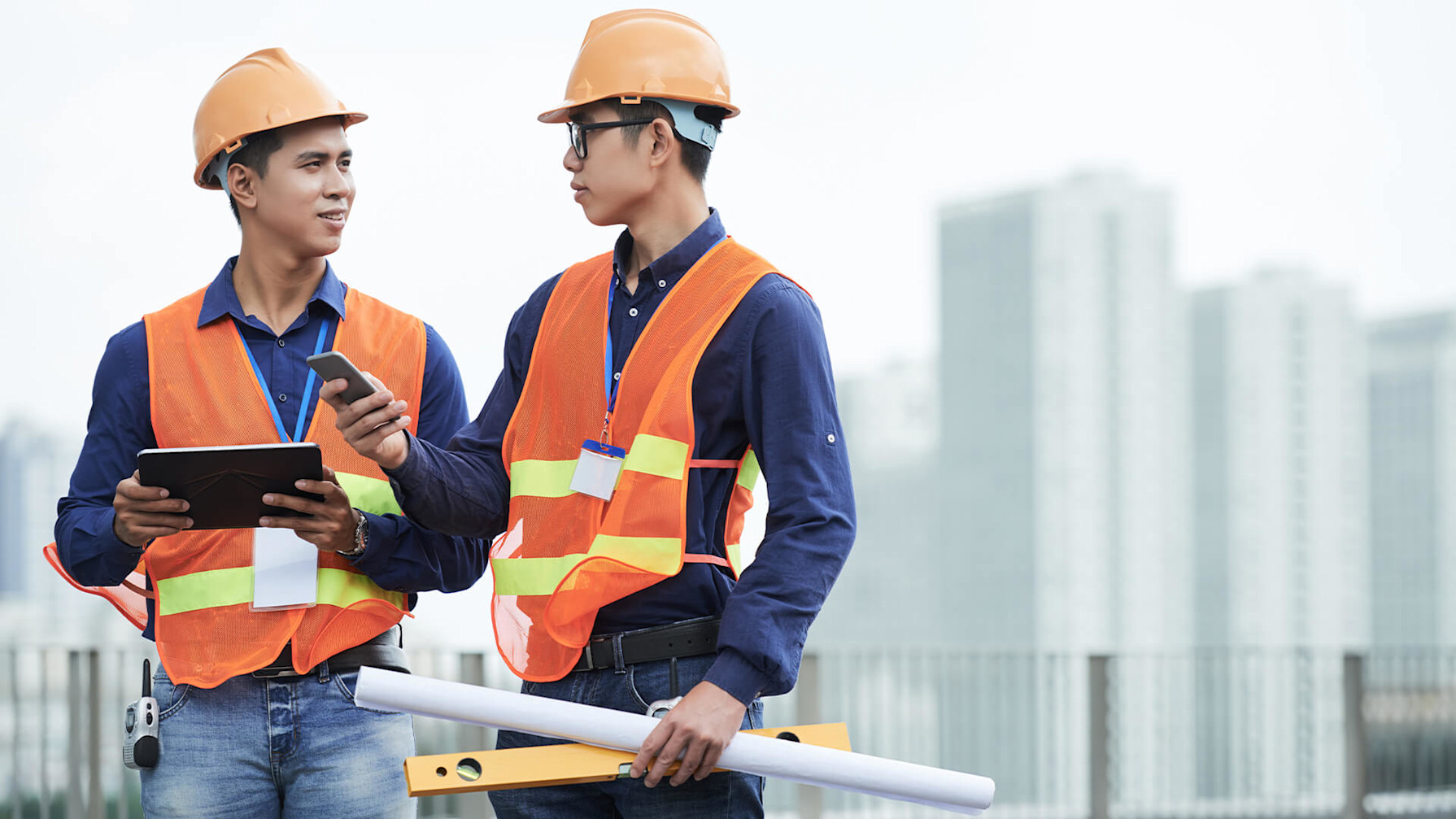 Contractors holding a tablet and blueprints