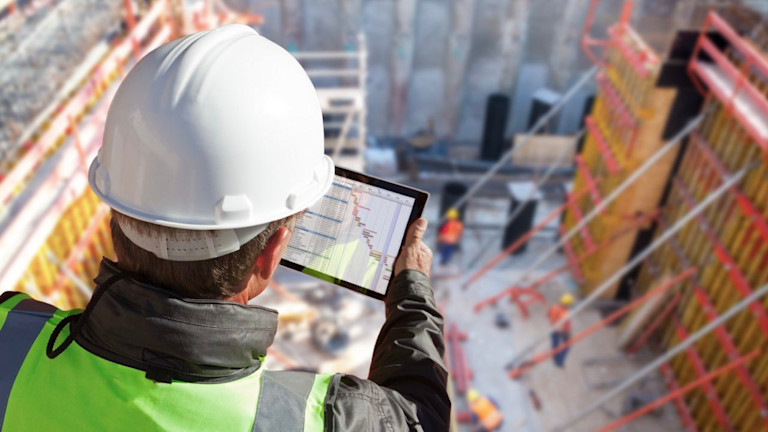 Image of construction worker reviewing plan on a tablet