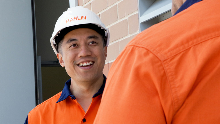 A Haslin construction worker smiling while having a conversation