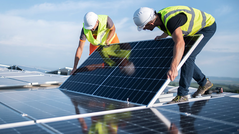 Construction workers setting up solar panels