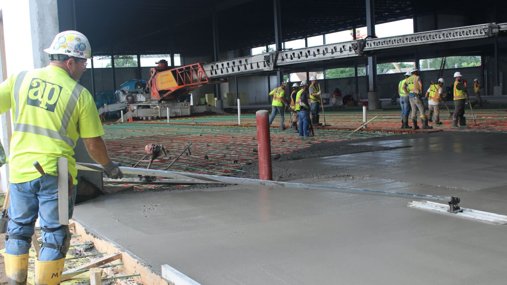 Contractors smoothing out concrete