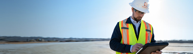 Contractor on an empty site using Procore on his tablet