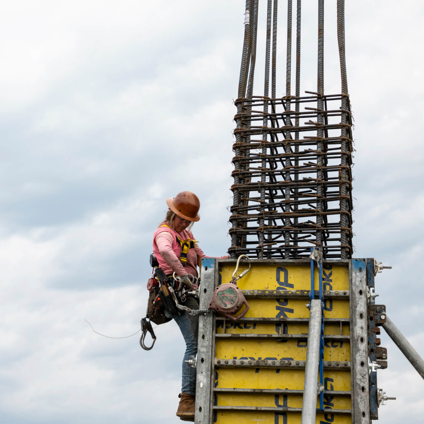 A construction worker climbing a column