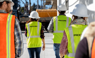 Contractors walking wearing Procore's uniform