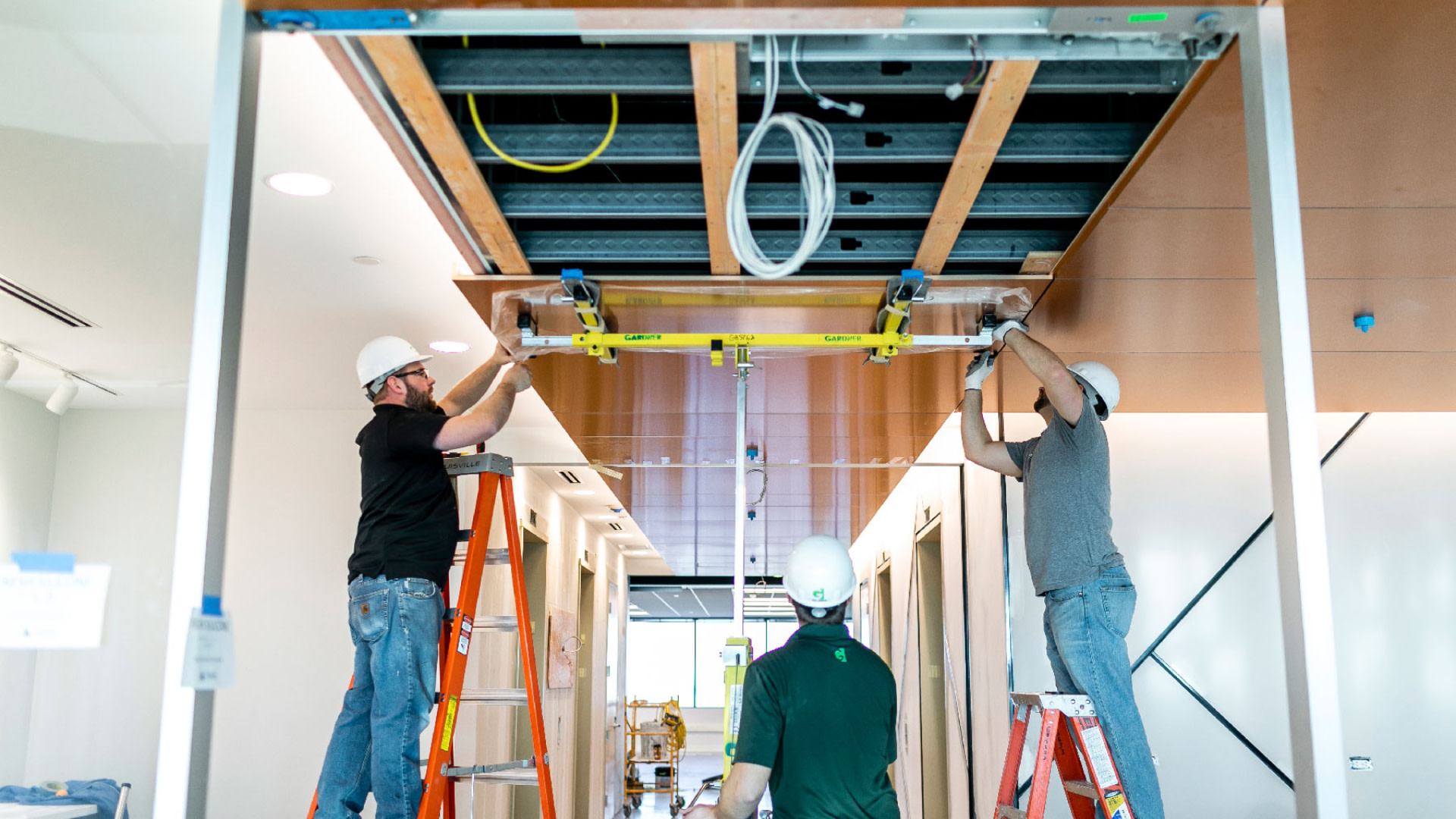 Three construction workers fixing a ceiling