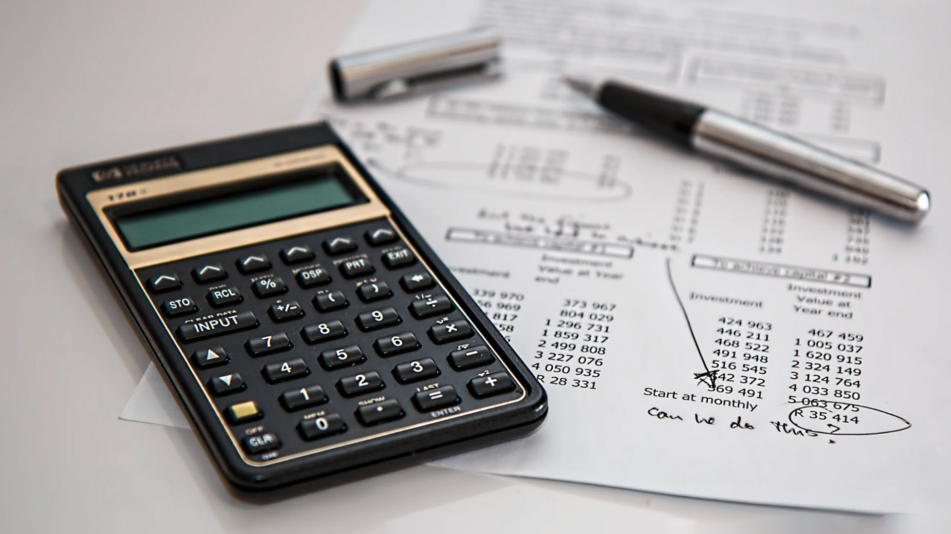 a calculator and pen on a paper