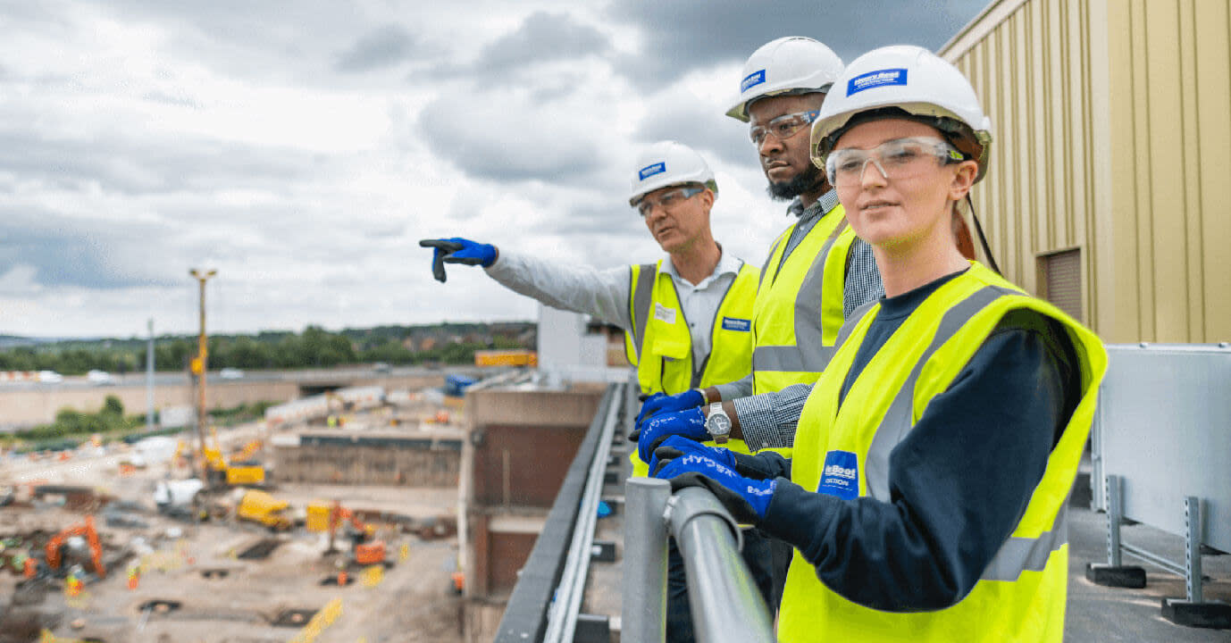 Three construction workers looking over a construction site