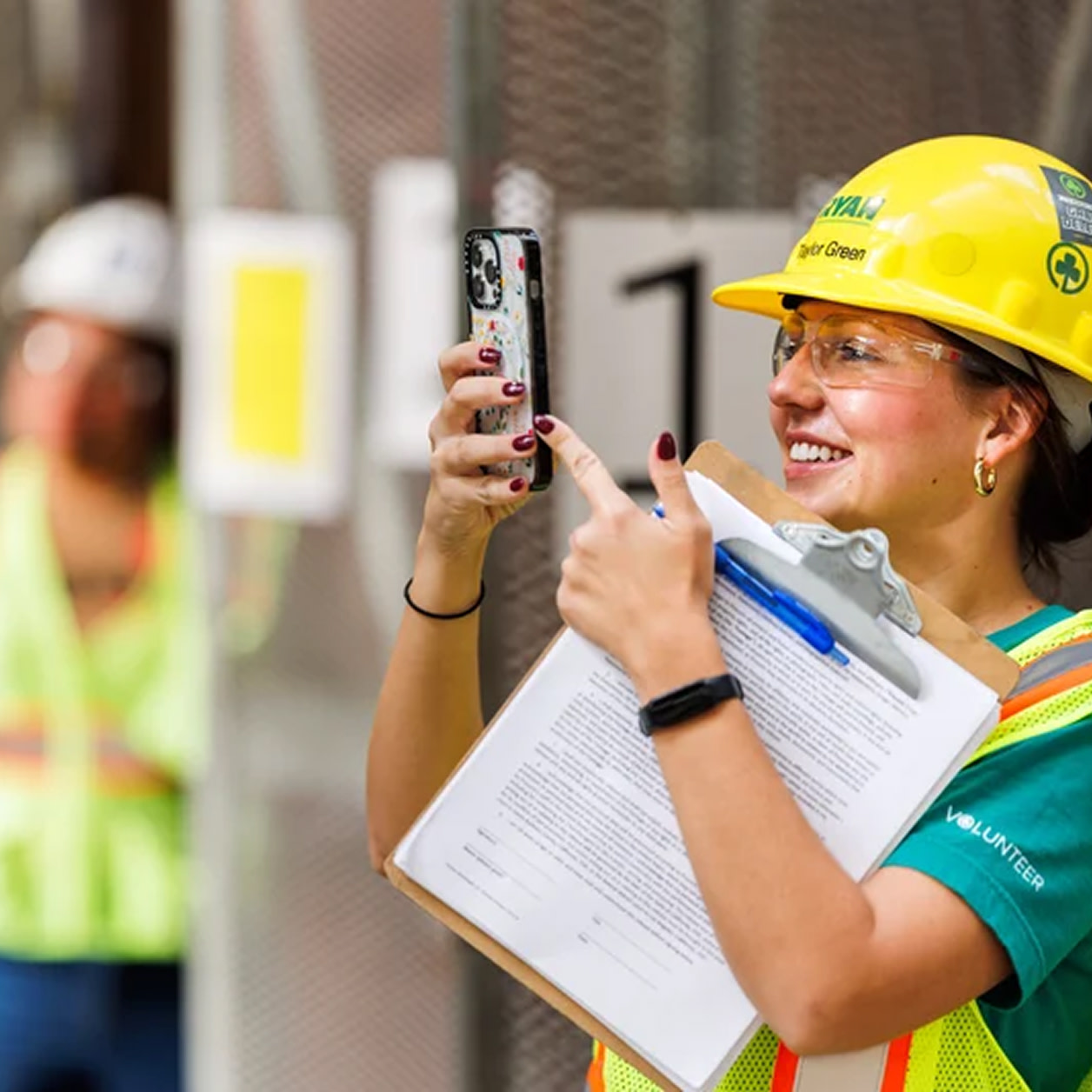 A woman contractor taking a picture of a construction site on her phone