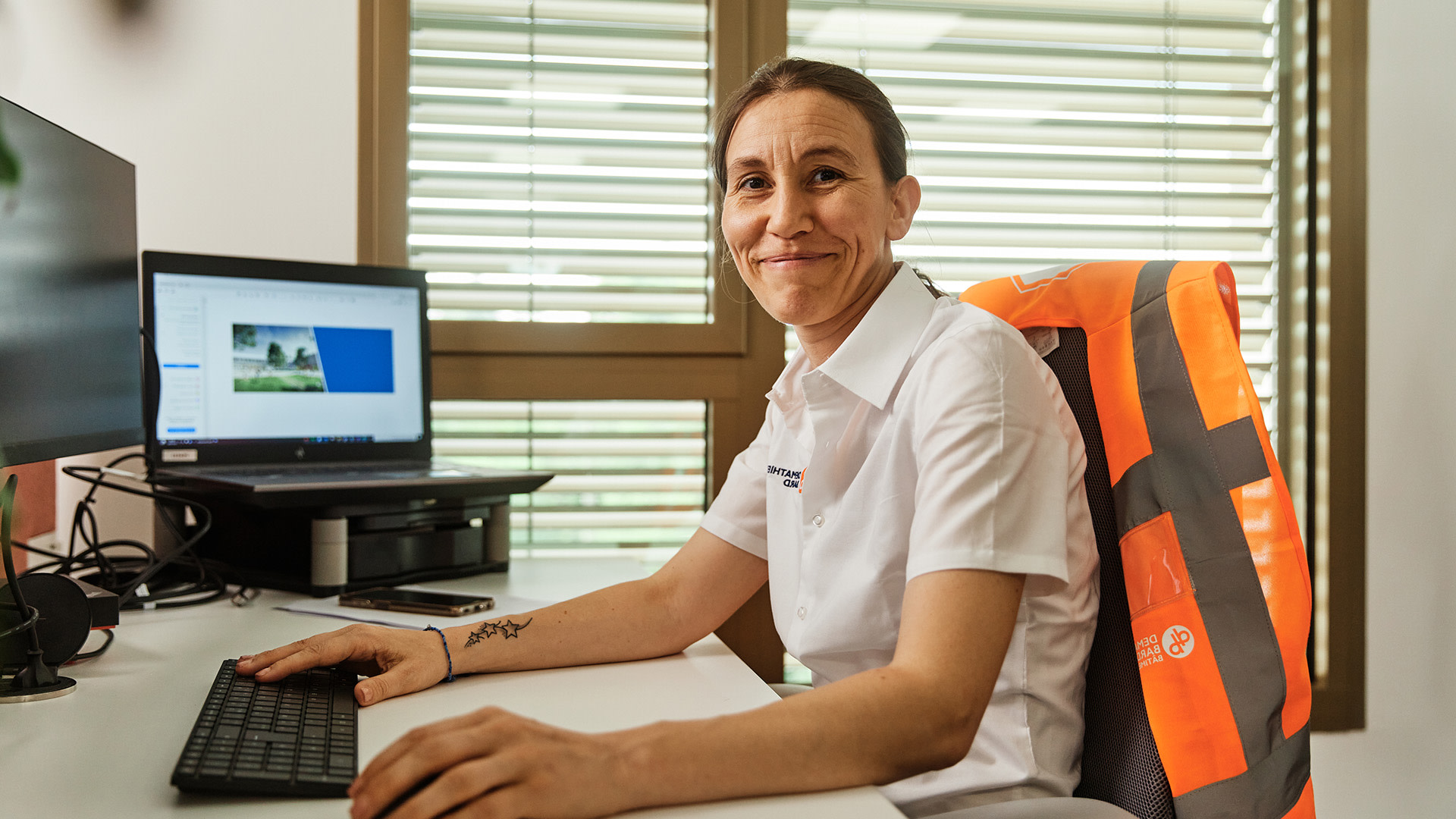 A woman sitting at a desk working with a laptop